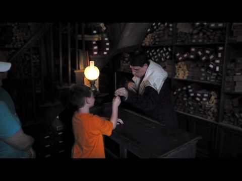 A wand chooses a boy inside Ollivanders Wand Shop in The Wizarding World of Harry Potter