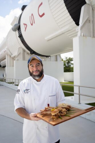 Chef with culinary offerings under rocket