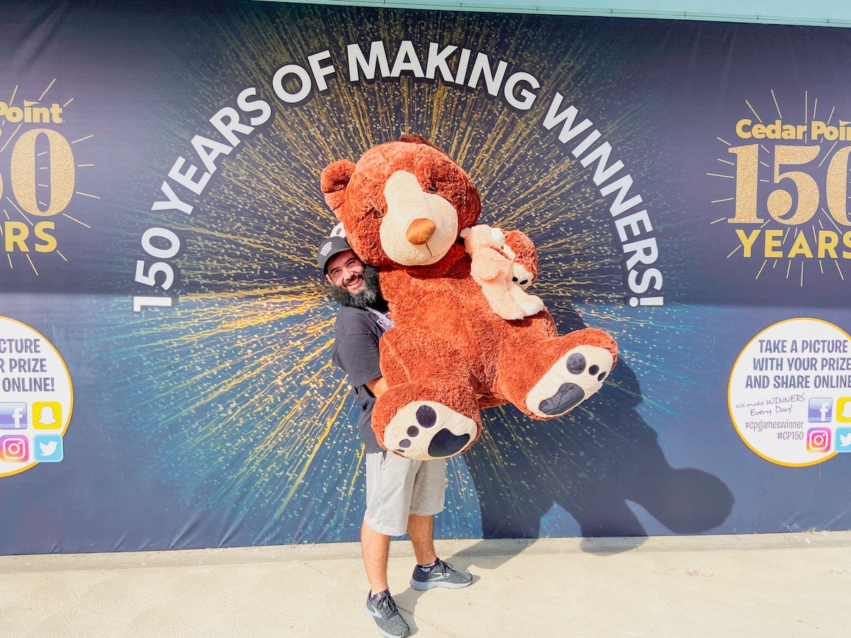 Spencer Coleman of Winner Every Time holding a teddy bear at cedar Point theme park - how to win carnival games