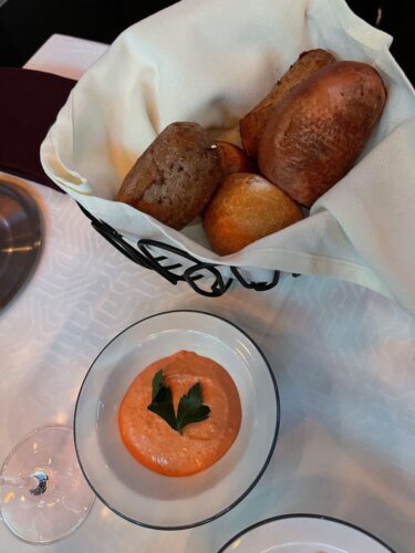 Bread service with a red pepper dipping sauce.
