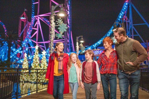A family strolling through Knott's Merry Farm with holiday decor