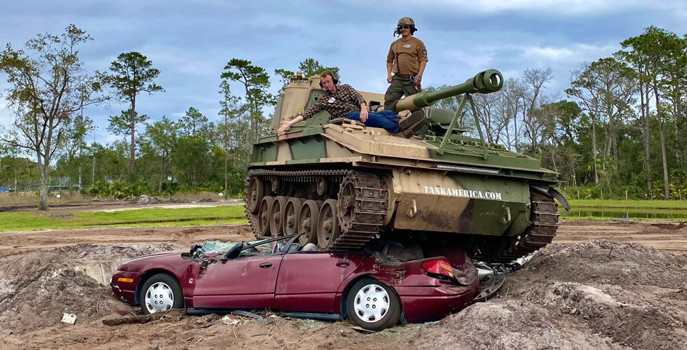 Reporter Tharin sits atop the Abbot tank after crushing a car at Tank America.