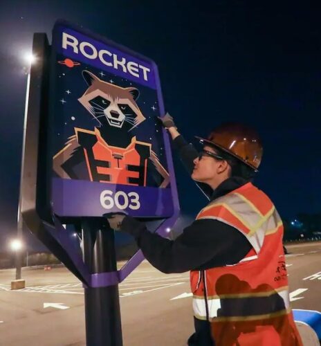 An imagineer installs a Rocket sign at Epcot