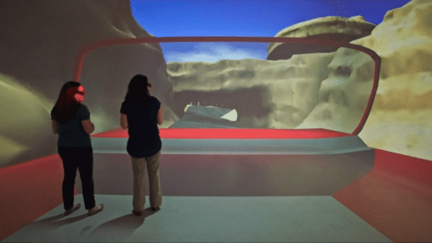 Two Imagineers stand in a wrap-around virtual reality screen