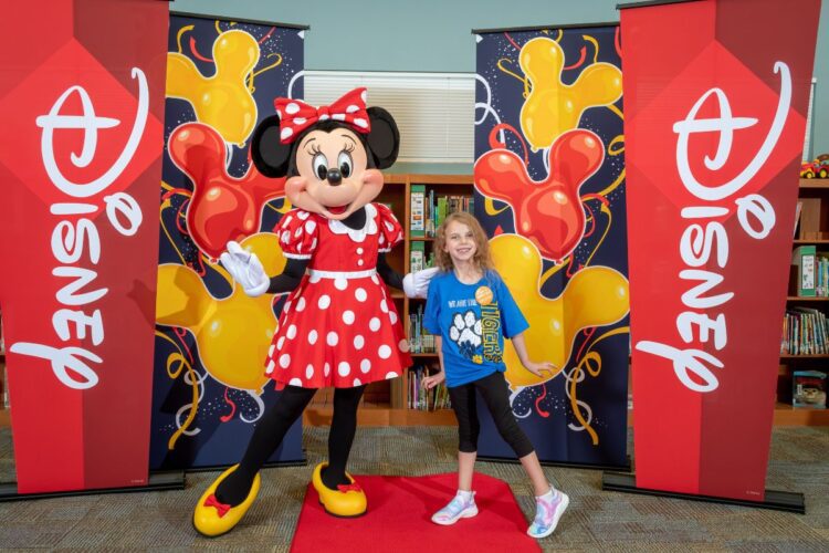 Scarlett poses with Minnie Mouse at her school.