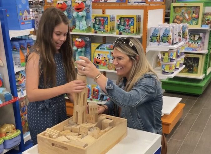 Paula and her daughter play with blocks inside a Toys"R"Us section inside Macy's.