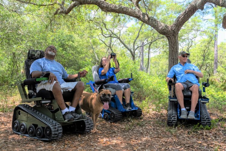 Group outdoors in EcoRover tracked wheelchairs