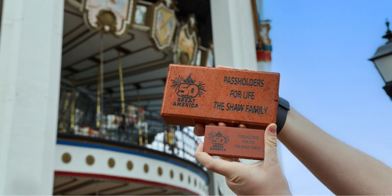 Hands holding Six Flags Great America anniversary brick