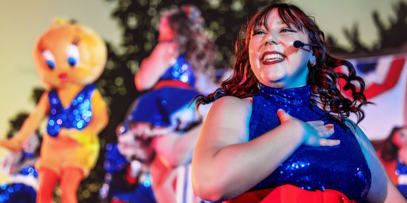 Dancer wearing mic and sparkling blue top at Six Flags Great America.