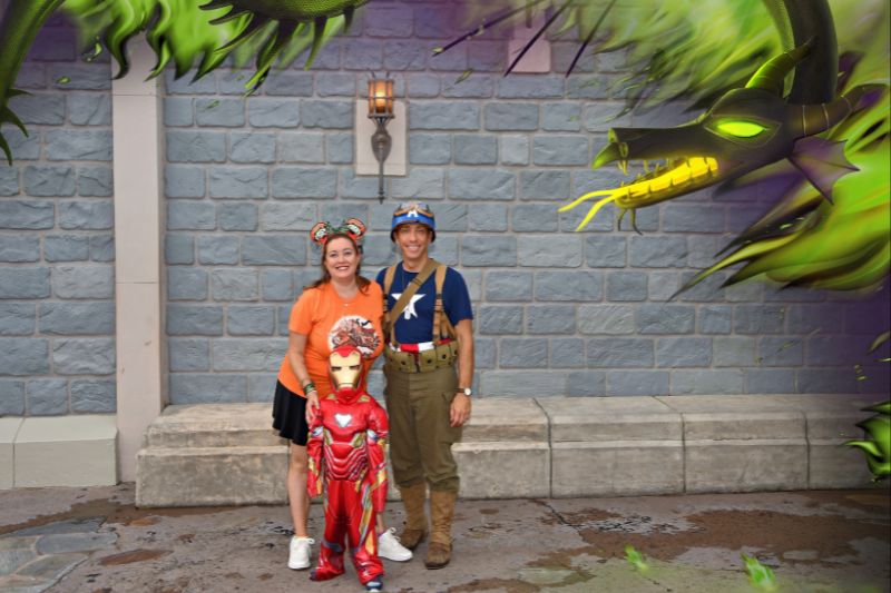 Family of three pose for Disney PhotoPass magic shot at Mickey's Not So Scary Halloween Party 