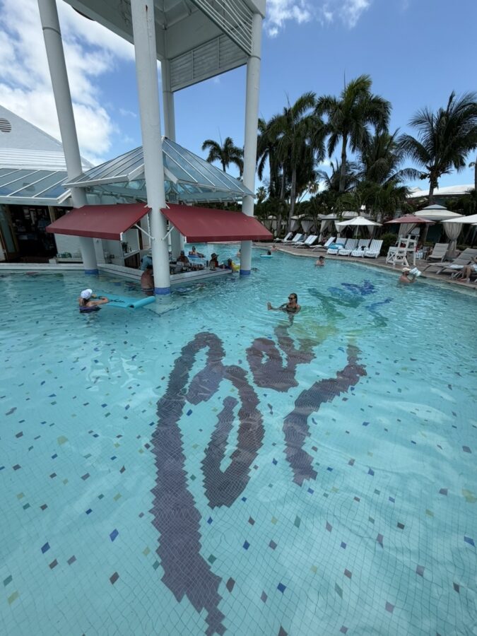 A swim-up bar with the word 'Beaches' at the bottom of the swimming pool. 