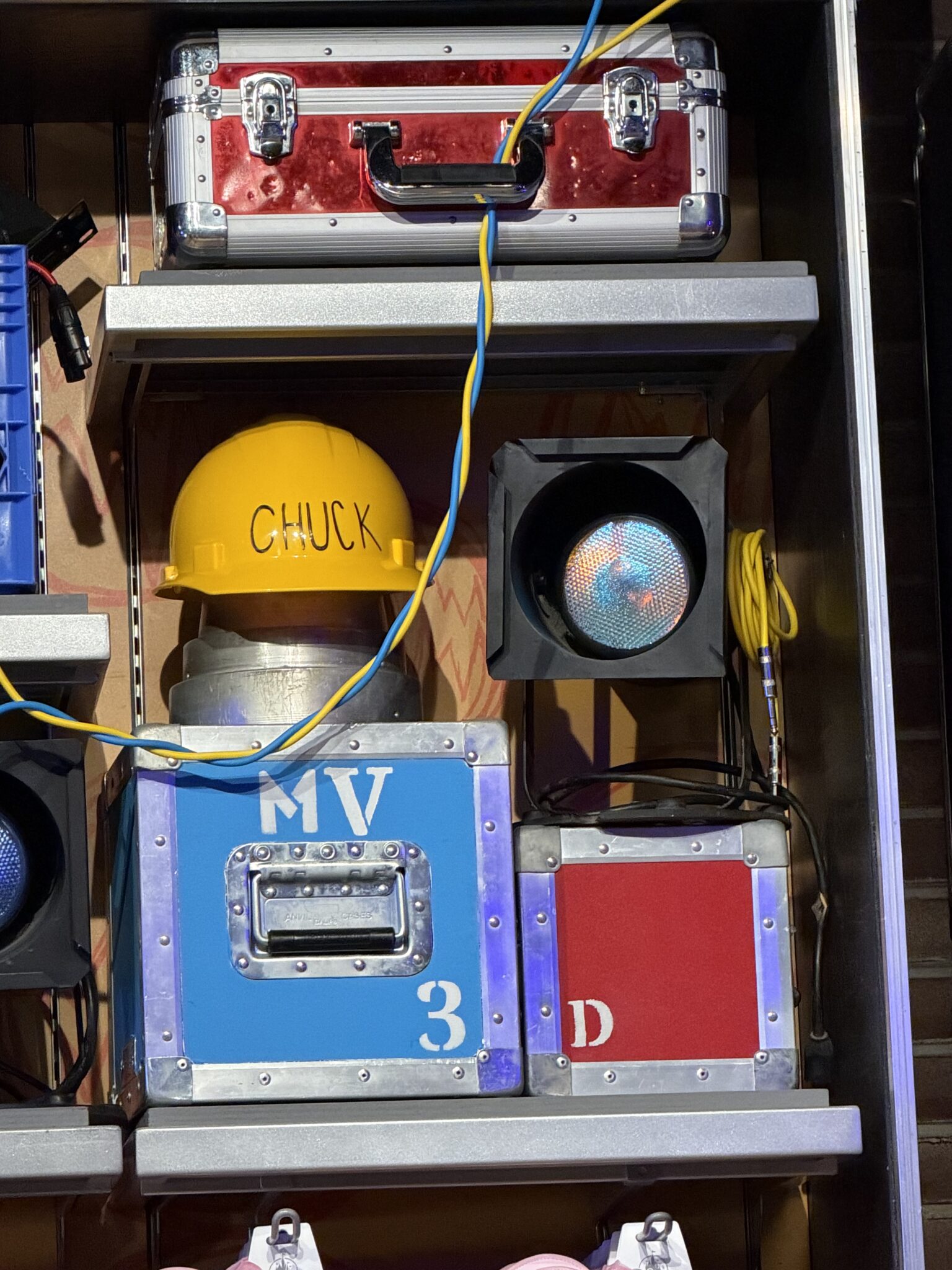 Chuck construction hat and live show production boxes on shelves
