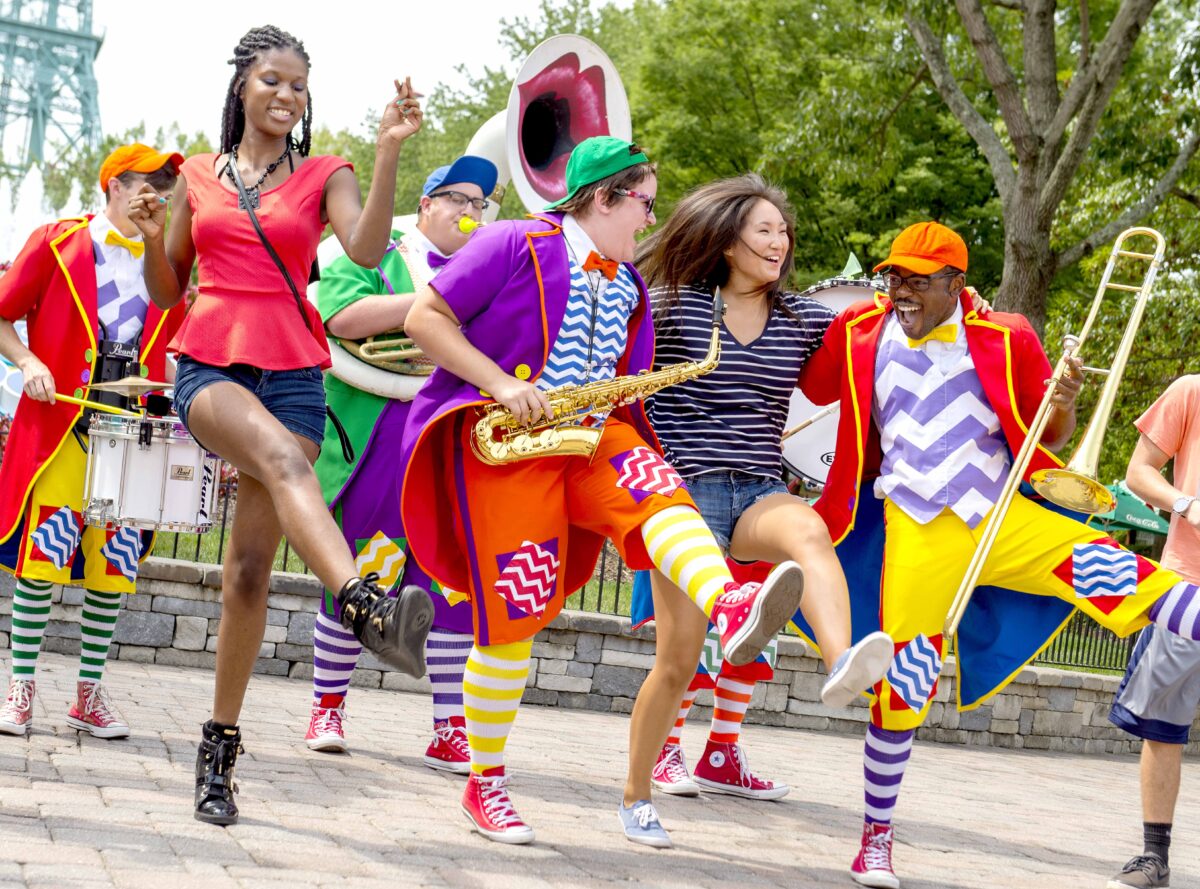 marching band in colorful costumes performer with guests at kings dominion