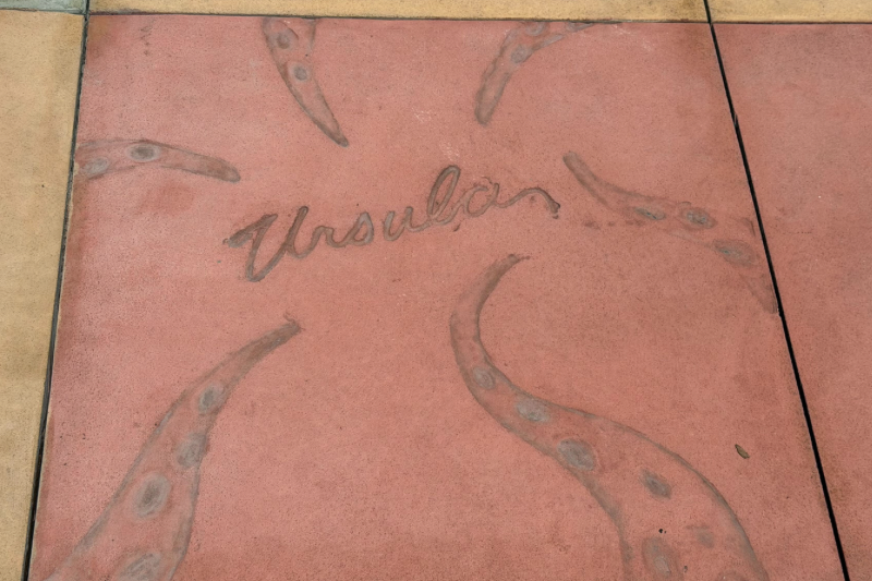 Character Ursula signature and handprints, but as tentacles in the cement