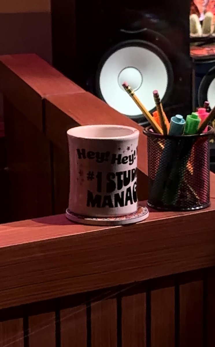 "Hey! Hey! Hey! #1 Studio Manager" mug on Scooter's desk.