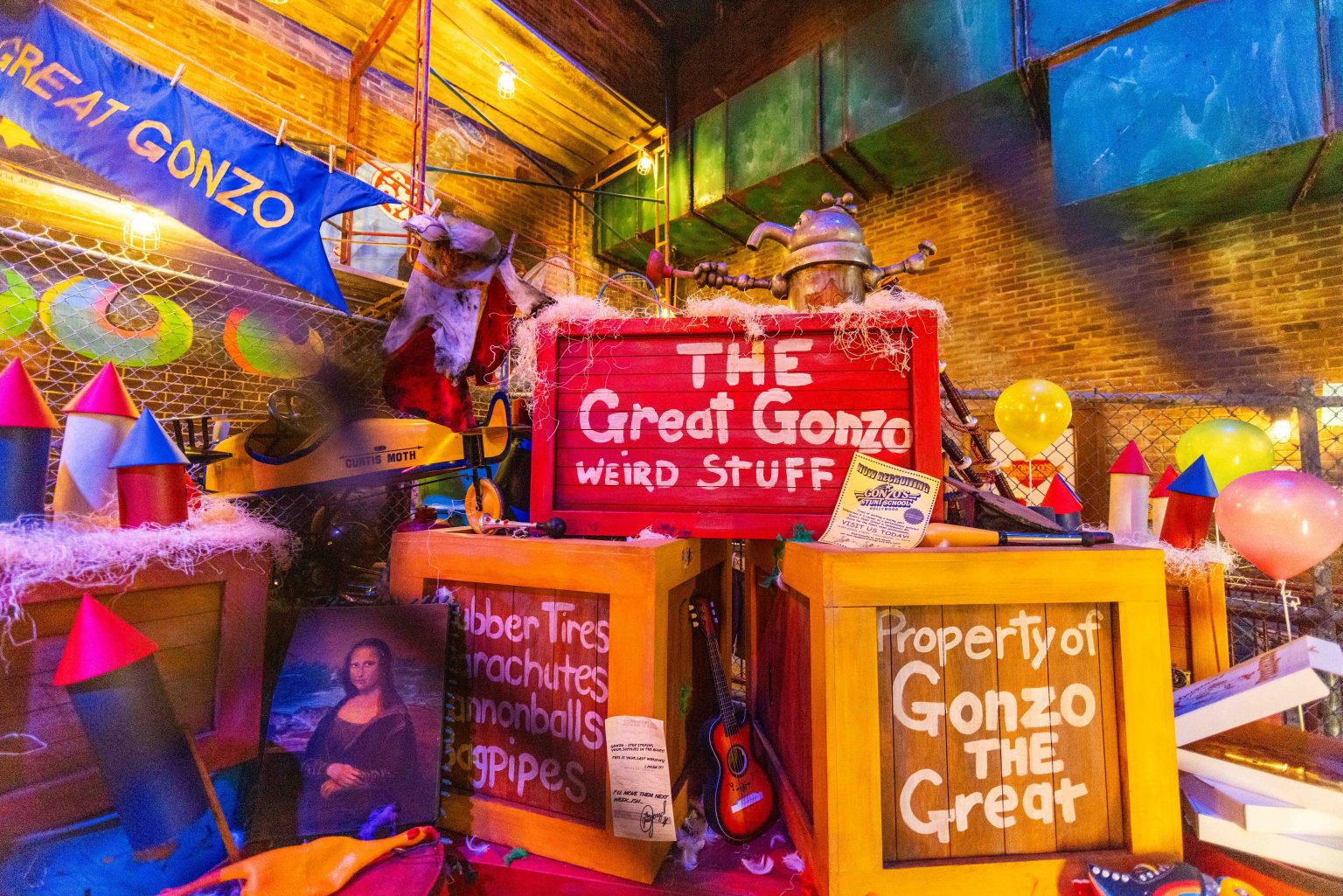 The Great Gonzo's crates, plane, and banner and props in a corner