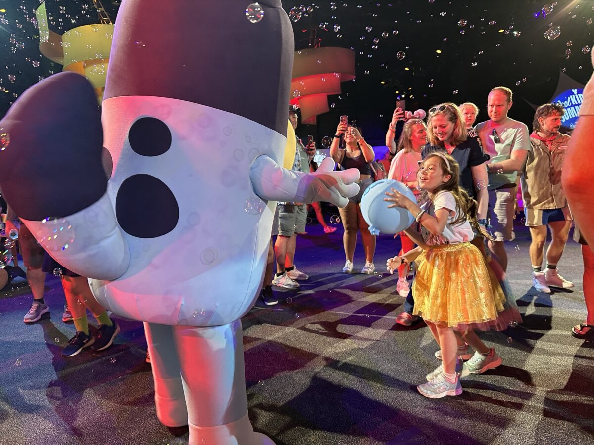 a girl plays keepy uppy game with a bluey character