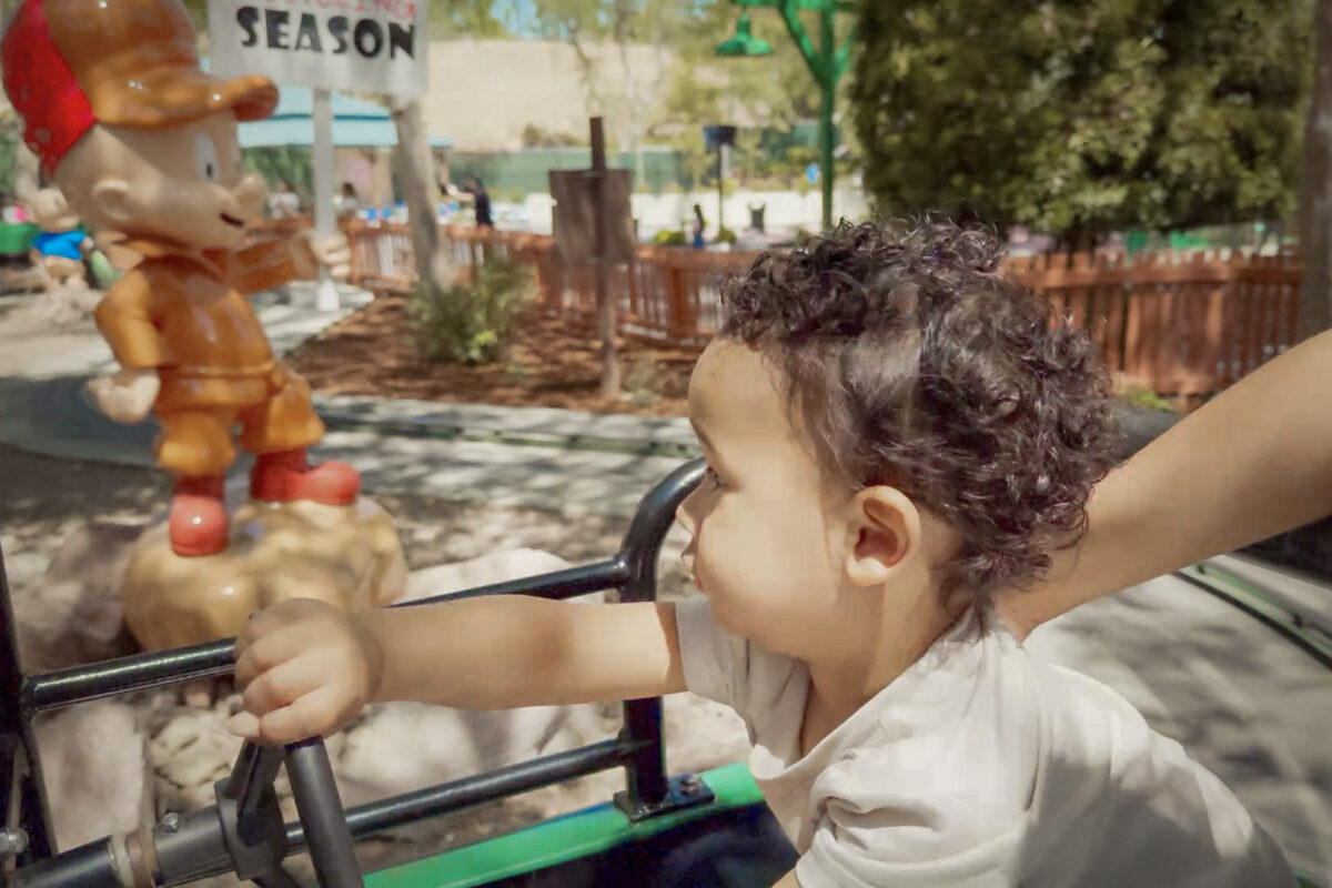 A Baby rides past a statue of Elmer Fudd