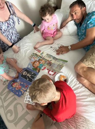 Kids on bed together during breakfast Disney Wish stateroom