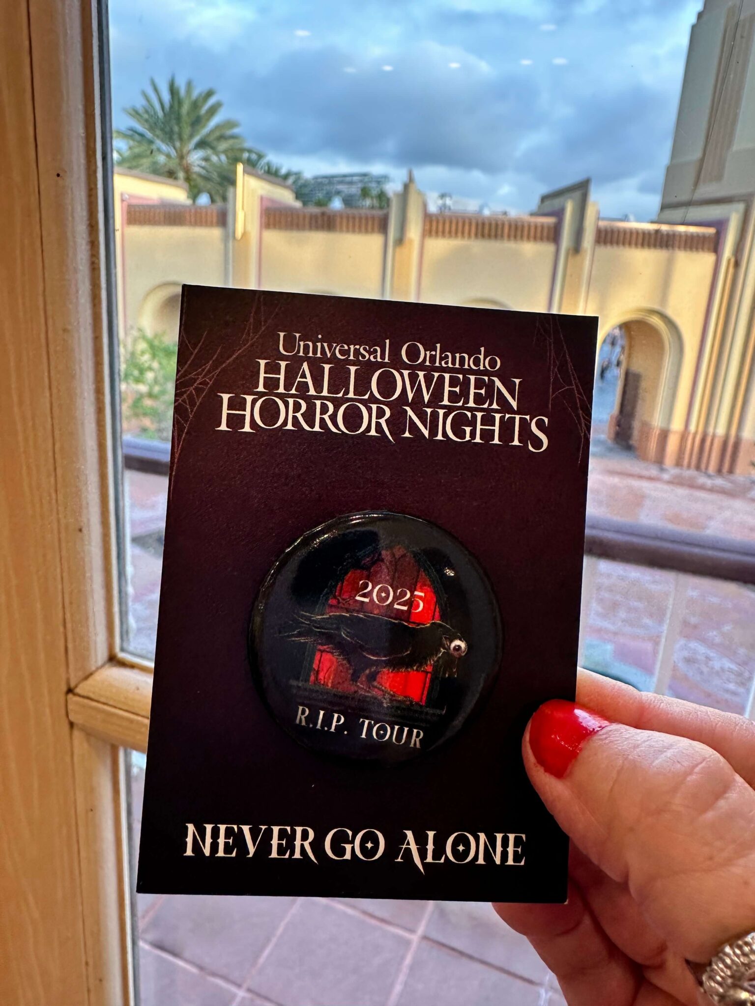 R.I.P. Tour Halloween Horror Nights button held in front of camera
