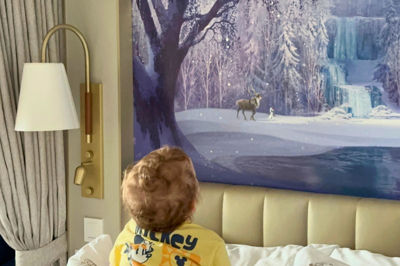 Toddler boy looks at Frozen artwork in Disney Wish stateroom