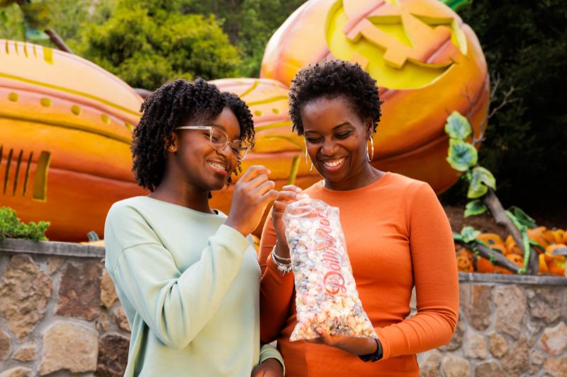 promotional photo of two women with kettle korn at dollywood with pumpkin