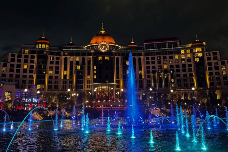 Epic Universe fountains and blue lights at night Helios Grand Hotel 