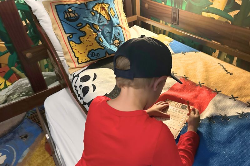 boy works on scavenger hunt in room Pirate Island Hotel - Photo by Dani Meyering