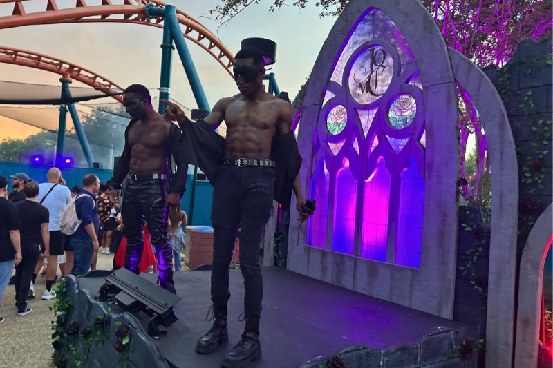 masked man with airbrush abs on stage at One More Chapter Dark Romance scare zone Howl o Scream Orlando