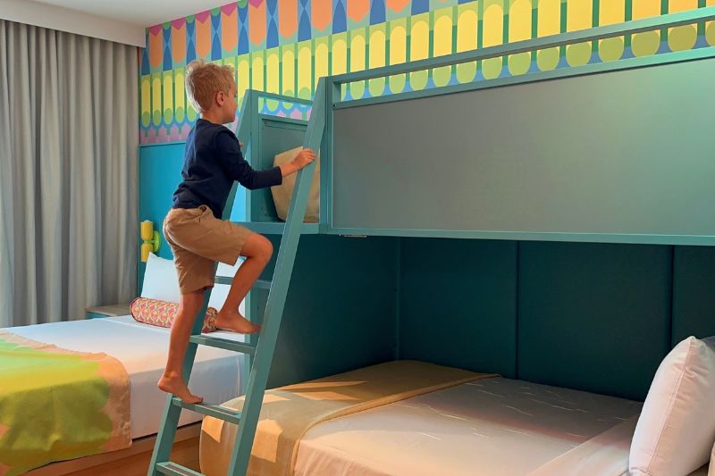 Boy climbing into bunk bed Universal Kids Resort Hotel