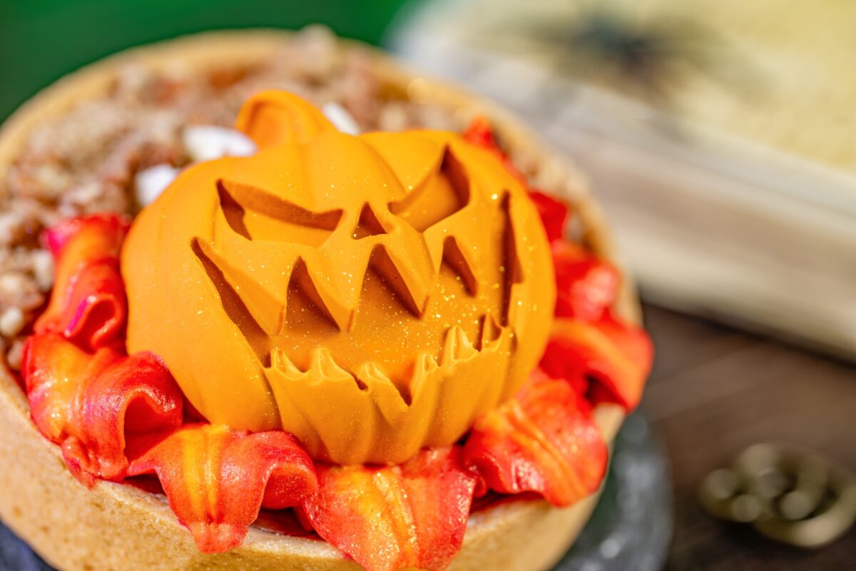 promotional photo of a pumpkin pie tart with whipped cheesecake, spiced caramel panna cotta, candied pecans and marshmallow buttercream “flames.”