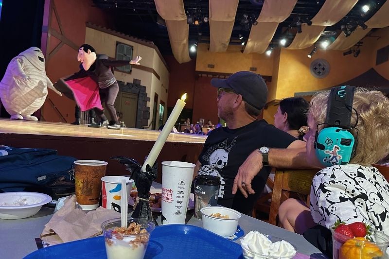 Father and son watch performers on stage during Hotel Transylvania Breakfast at SeaWorld Orlando