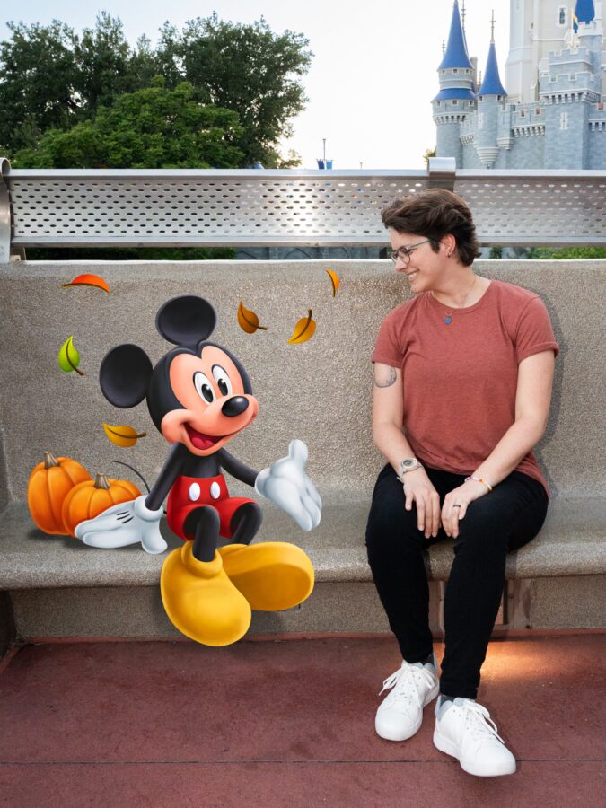 mickey mouse poses beside pumpkins