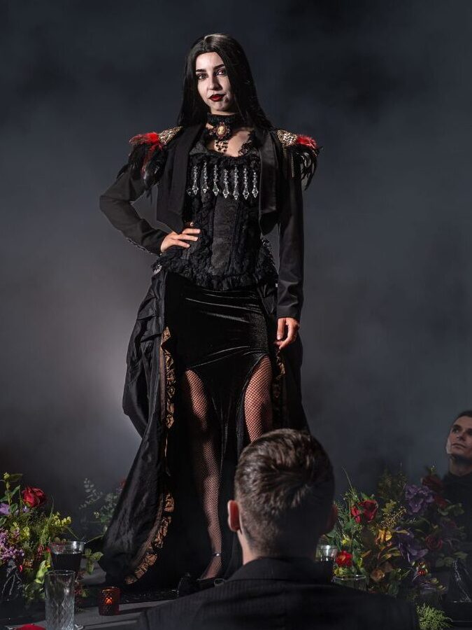 costumed performer on a halloween themed table with onlooking guests
