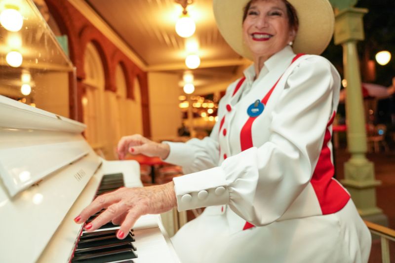 Carol playing the piano at Casey's Corner at Magic Kingdom.