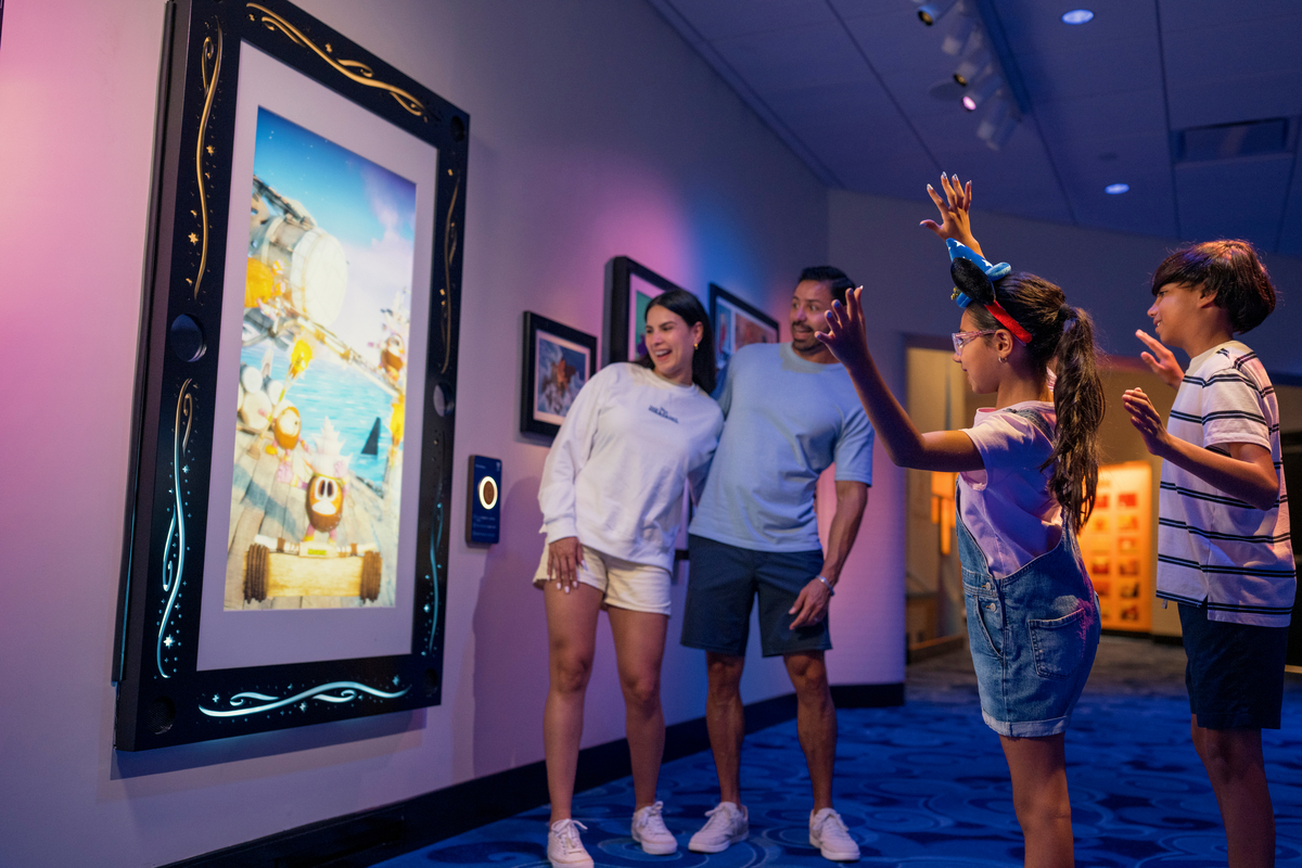 Promotional photo shows family with iteractive poster with Moana characters