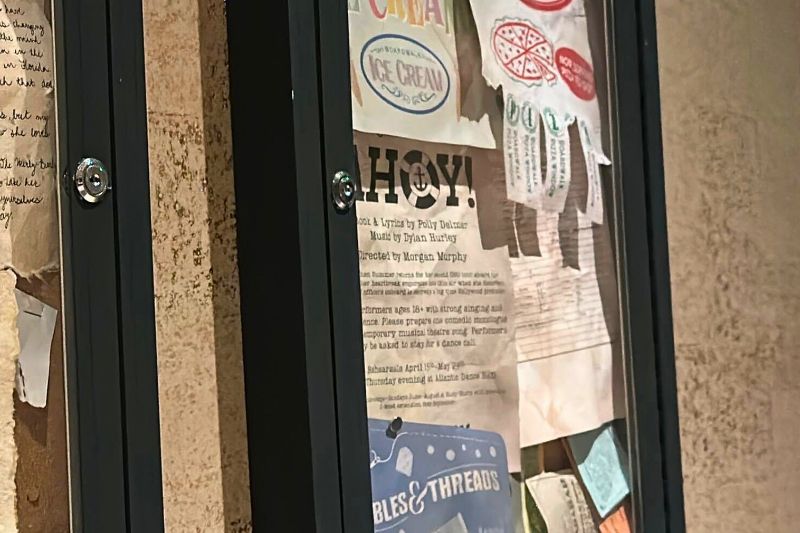 Props, letters, flyers on display at Hurly-Burly, near the restrooms, zoomed in to possible sign in sheet