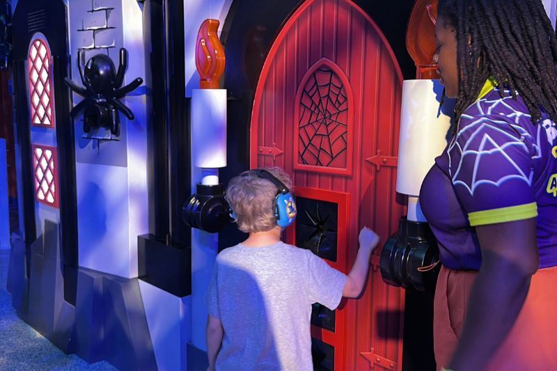 boy knocking on door of Spider Lady's Castle Brick or Treat Street Legoland Florida 