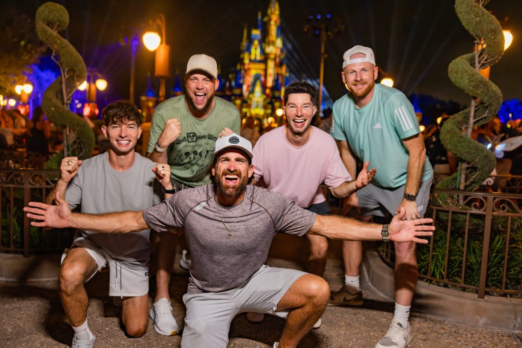 Dude Perfect group posing at Magic Kingdom at night