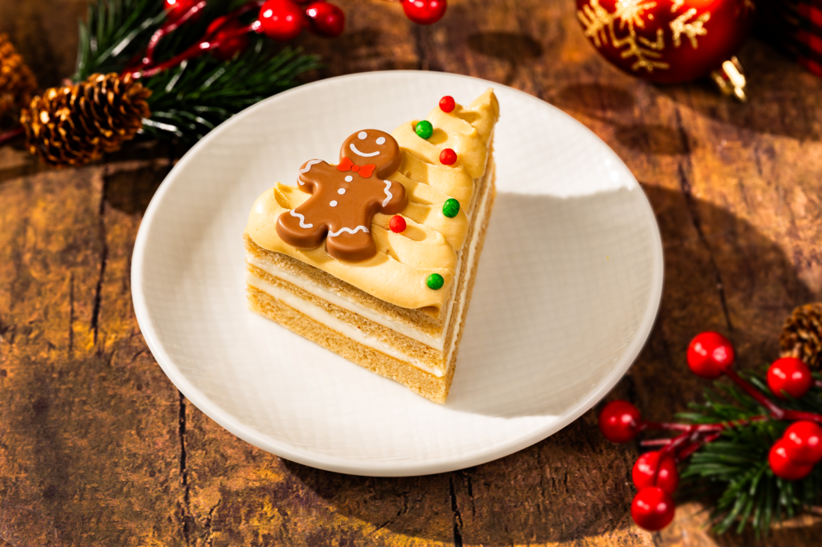 A slice of gingerbread cake topped with frosting and a gingerbread man decor, highlighting festive Disney World Christmas treats.