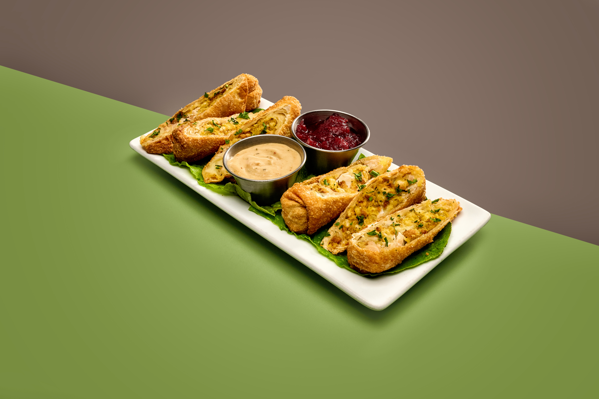 Crispy Thanksgiving egg rolls served with dipping sauces on a rectangular platter, featuring as one of the Disney World Christmas treats.